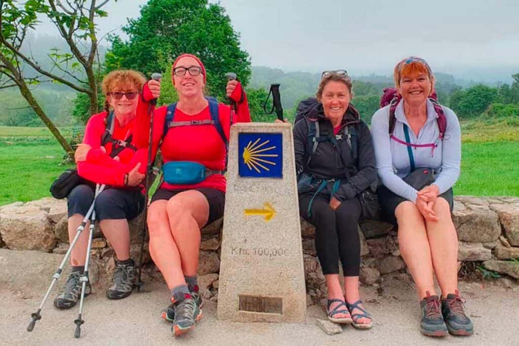 colleen with pilgrims at the 100 kilometre marker on the Camino Frances