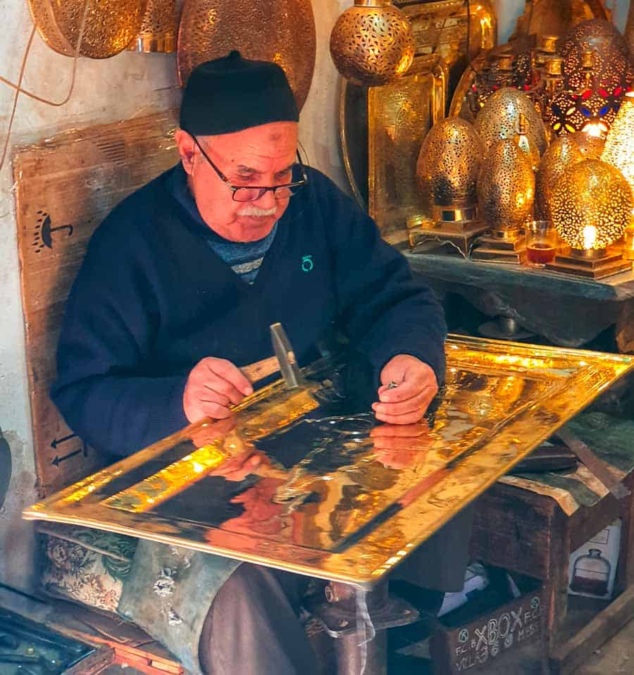 artisan at work on copper art in the Medina in Marrakech