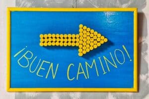 yellow arrow and the expression Buen Camino on a sign in a bar along the Camino de Santiago