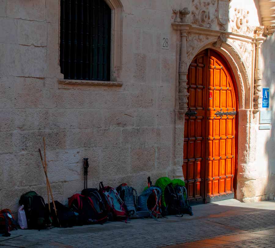 rucksacks queued at the door of the pilgrim albergue in burgos