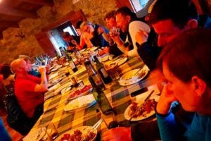 communal dinner at Fonfria on the Camino Frances with many pilgrims around the table and lots of food and wine