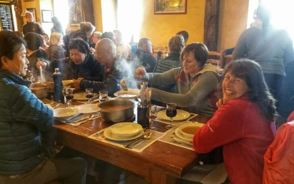 pilgrims enjoying hot soup in an albergue on the Camino Frances