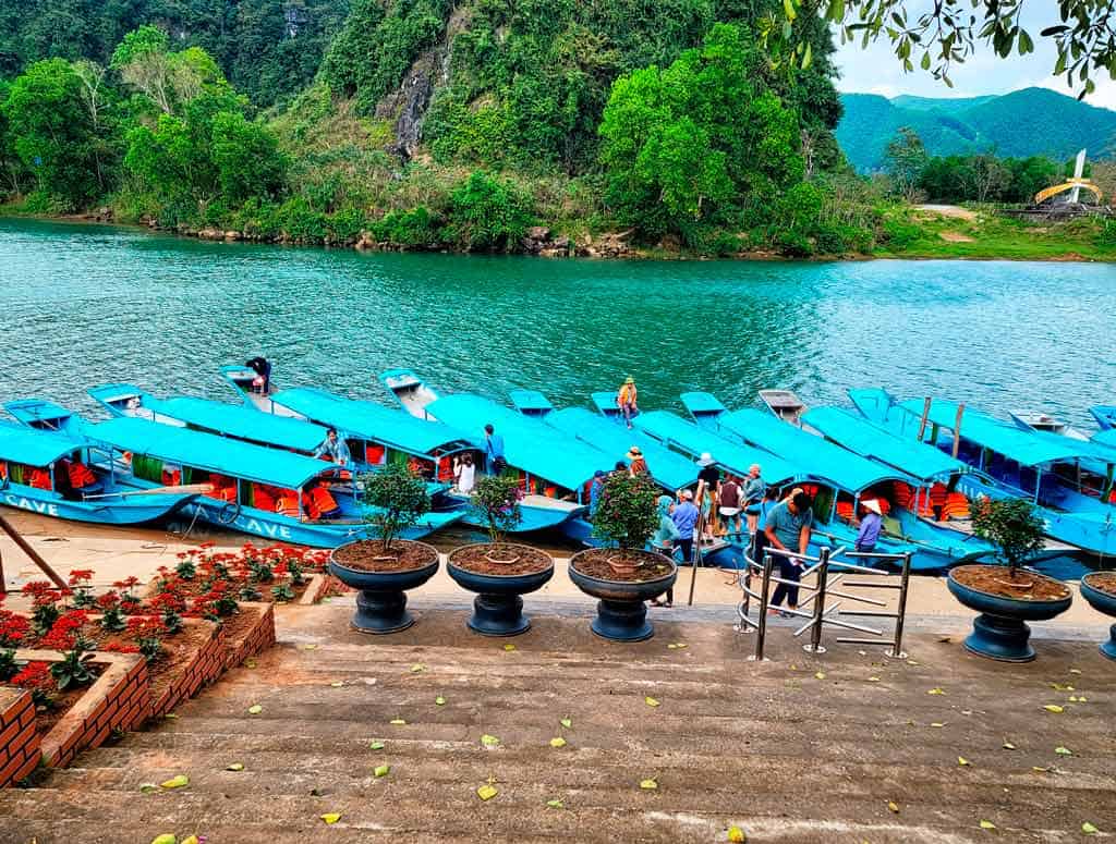 traditional blue boats lined up waiting for passengers in Phong Nha