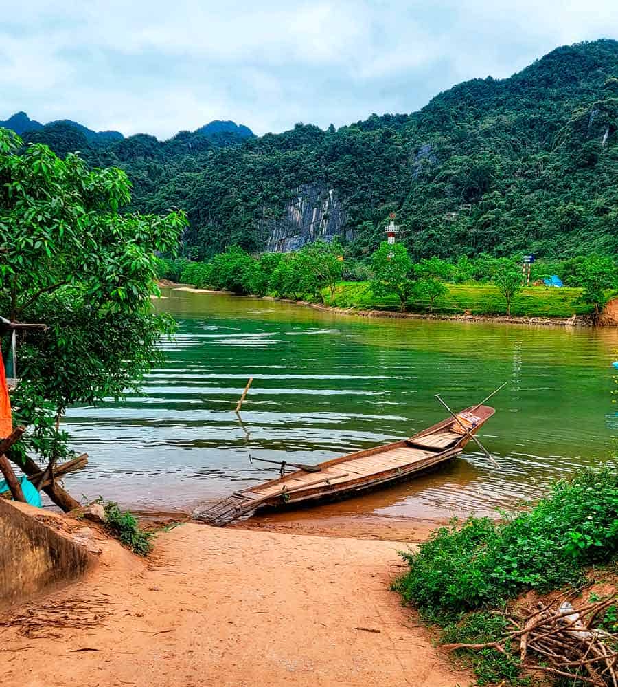 very old wooden ferry for bikes crossing Son river in Phong Nha