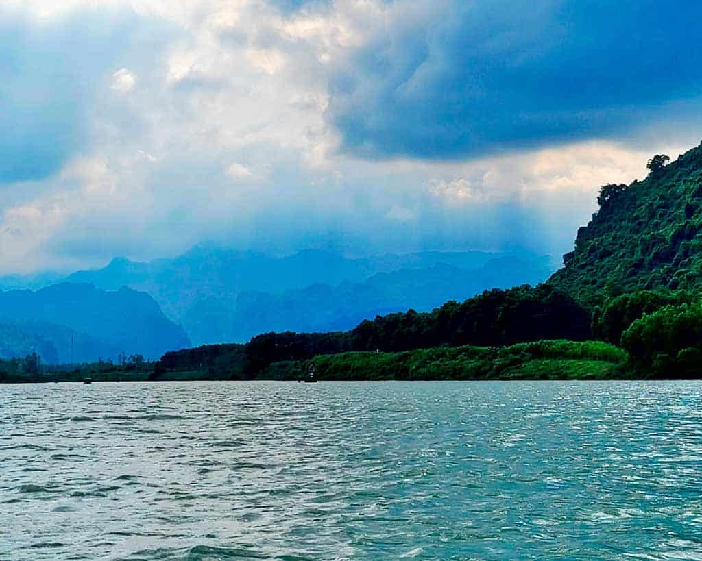 View of the river from the banks with the mountains in the distance