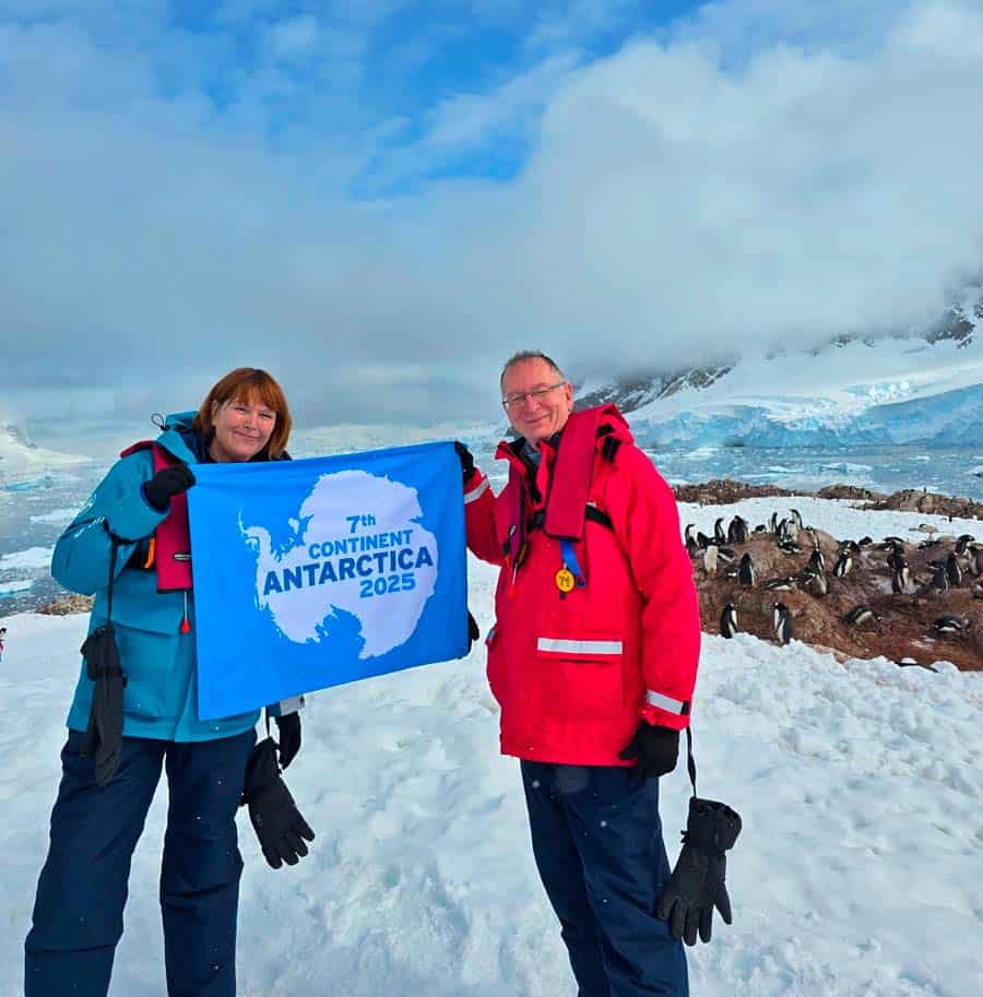 colleen and gerry holding an antarctica banner