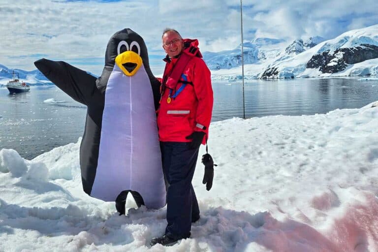 Gerry on Antarctica with on of the cruise crew dressed as a penguin
