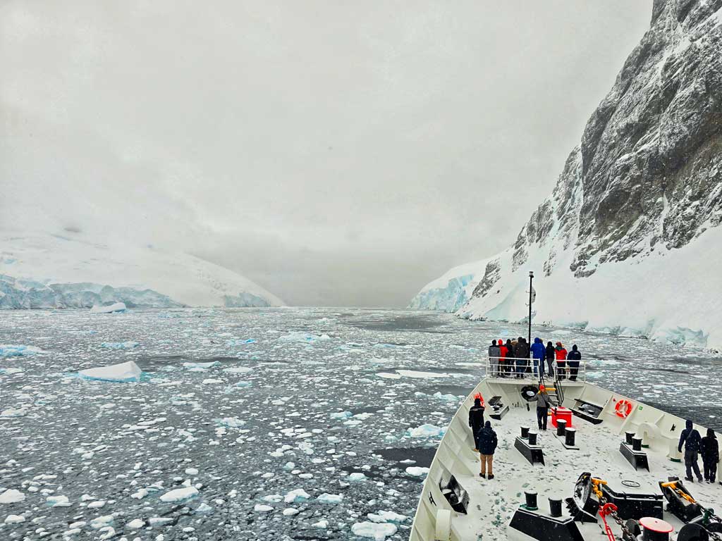 our antarctica cruise passing through the lamaire channel with sea ice and morning mist