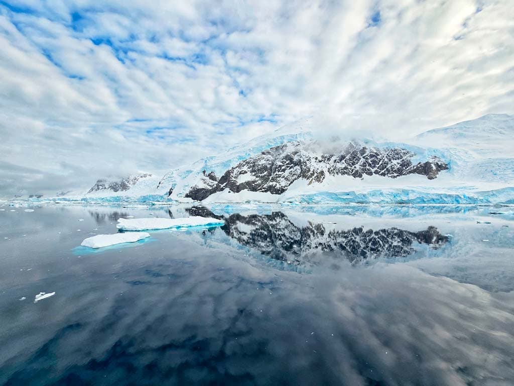 perfect reflection of antarctica mountains in the calm sea
