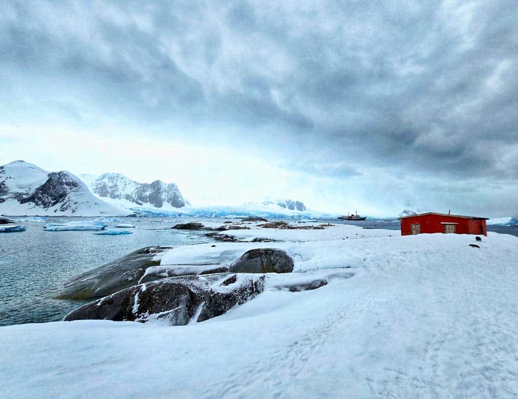 view from our hike on petermann island with a research station and our ship in the distance