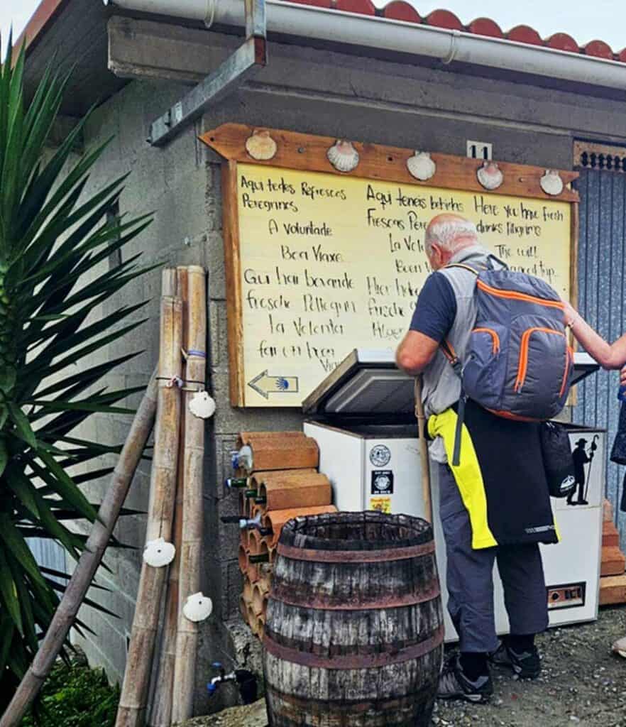 pilgrim looking at notice beside refreshments stop