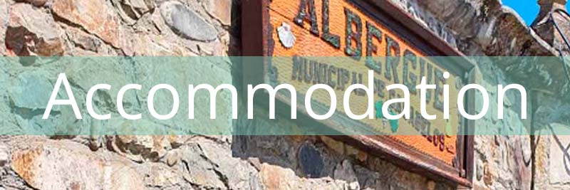 a wooden sign saying Albergue with a banner saying Accommodation