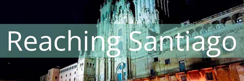santiago cathedral at night with the pale stone buildings against a dark sky