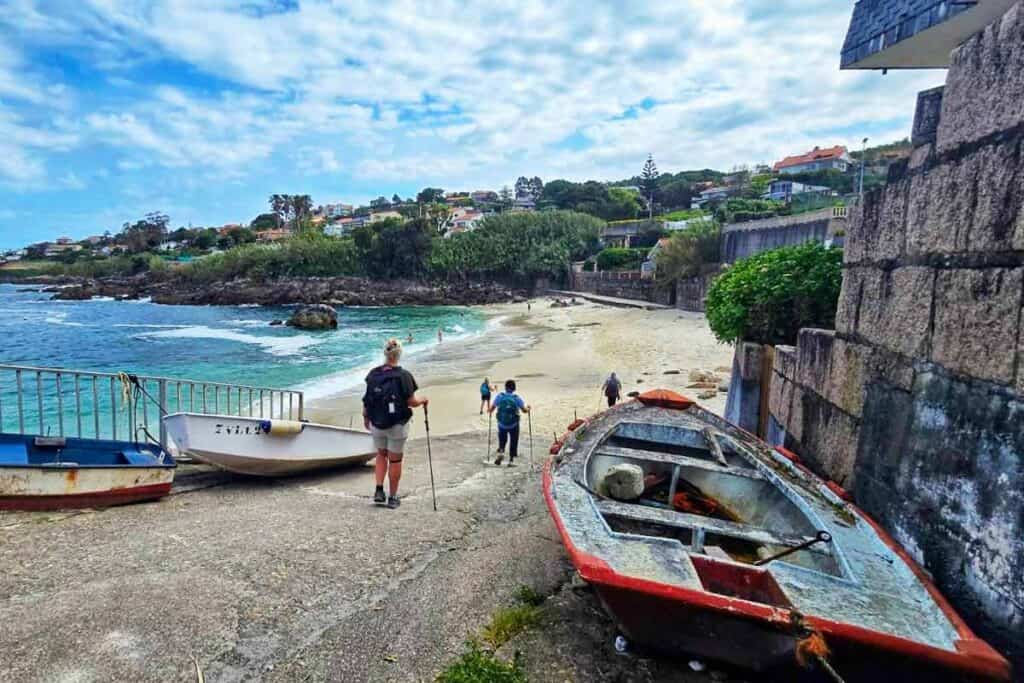 pilgrims walking the coastal camino on a beach near vigo