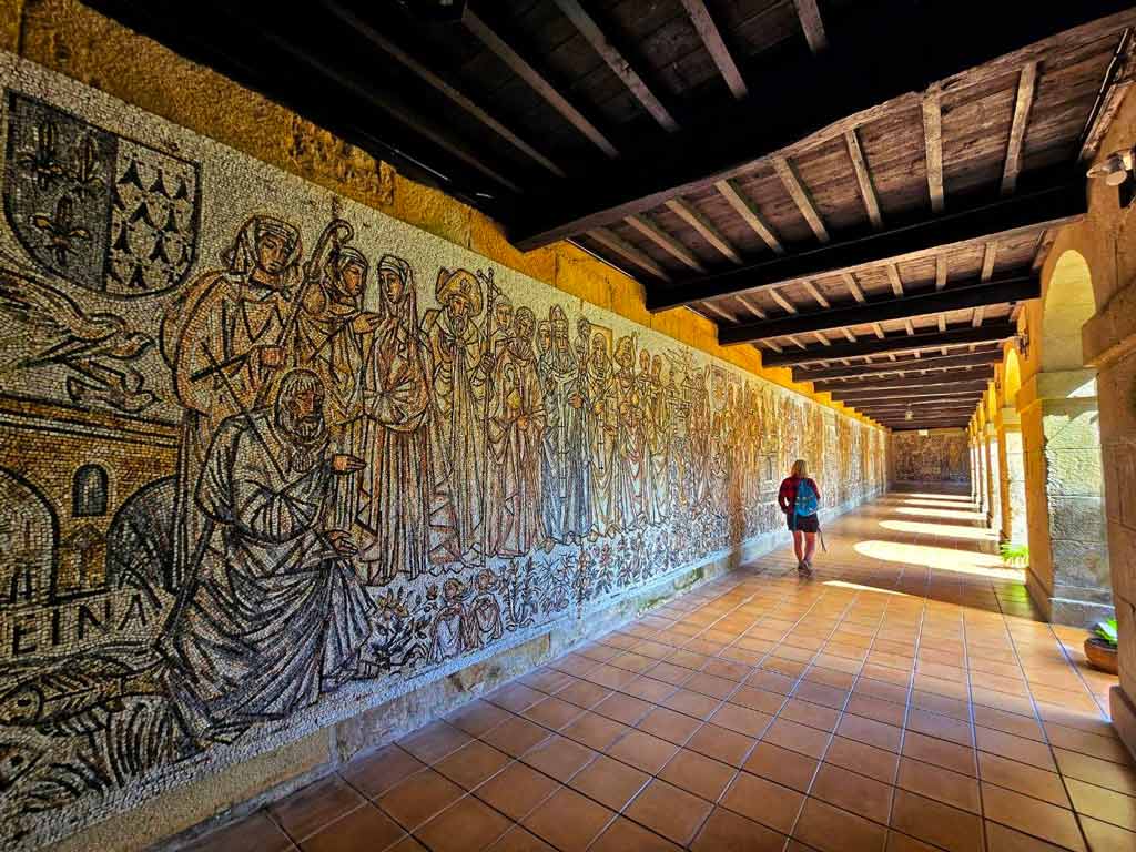 pilgrim walking beside the huge mosiac in Poio monastry